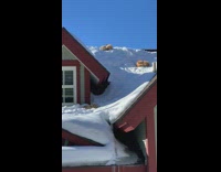 Cats laying on top of snow covered roof 