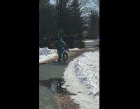 man in green runs next to kid on bike and falls on her