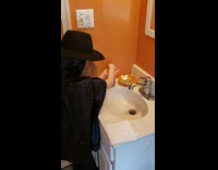 Boy in bird mask washes hands