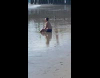 Man shirtless sit on sand meditate beach