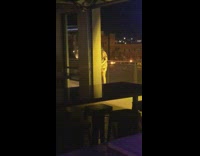 Woman in a dress poses at the building balcony