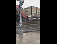 Guy freestyling in the rain on the sidewalk