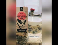 Girl bakes biscuits with black puppy dog 