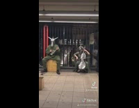 Two people wearing metal animal masks performing on street