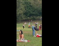 Orange shorts guy rides bicycle balances ball 