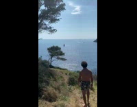 Guy walks towards blue lake in france 