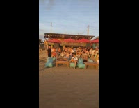 Woman takes picture with surfboard in sunset