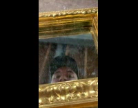 Guy paints sailboat on gold frame mirror 