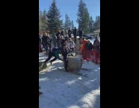 Guy rides on keg sled down snow