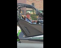 Guy and small dog ride ATV street