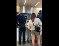 Man still in wetsuit on the line of the Erewhon market