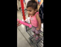 Little girl makes noise with plastic straw toy 