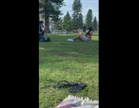 Girl sits on grass face mask park