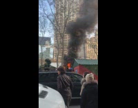 People look at large fire on street