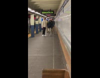 Person wearing giant round metal mask with a smiley face on it 