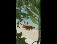 Old woman red bikini posing on beach 