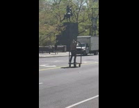 Bellboy surfing down street on bellman cart