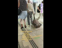 an older man dragging brown suit case