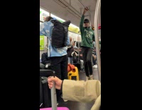 Man green jacket hyped and dances inside train
