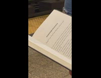 Man reads book called How to start your own religion in subway station