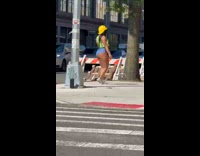 Woman wearing cropped construction vest dancing on street
