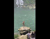 Woman bikini stand on a rock waterfalls