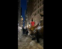 Guy balancing basketball climbs bull statue 