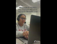 Girl grey jacket on laptop with headphones on