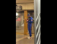 Man with Xenomorph on Chest Waits on Subway Platform