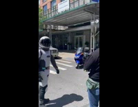 Person wears spacesuit films video on street