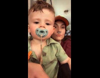 Boy shows fist while mom filming video