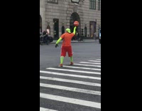 Guy wearing neon green arm sleeves and and leggings pretends to be crossing guard