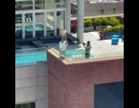 Woman blue dress stands edge of balcony pictorial