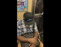 Guy falls asleep on subway train wears marquee hat that says Insane in the membrane brain