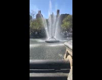 Guy standing inside of the water fountain at park