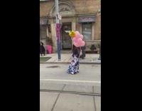 Woman blue dress pink balloons walk street