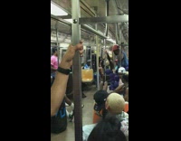 Woman in mesh outfit dances on pole like a stripper on the subway Pride parade