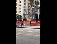 Two guys shuffle and dance down sidewalk 