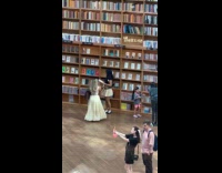 Collab IITW - Woman in skirt poses front of bookcases