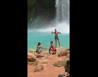 Guy flexes by waterfall light reflector