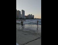 Lady in denim shorts stands and spins at beach 