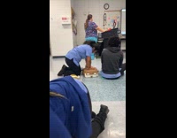 Woman blue shirt practice cpr with doll