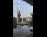 Photographer adjust golf club on girl shoulder 