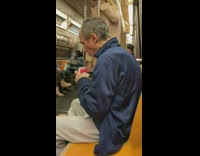 Man opening and drinking a can of beer on the subway