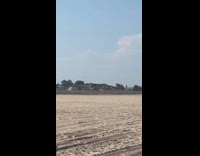 Woman chasing parasol caught by wind