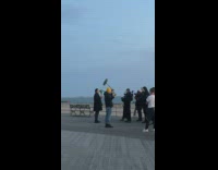 Man coat talk camera crew beach dock