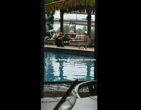 Man help girlfriend model video shoot poolside