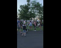 Dog on a longboard skating on at a riverside park 
