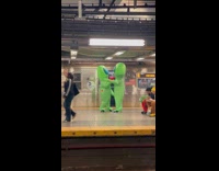 Two aliens kissing in the subway platform