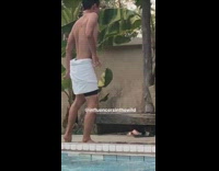 guy dances in towel tripod pool